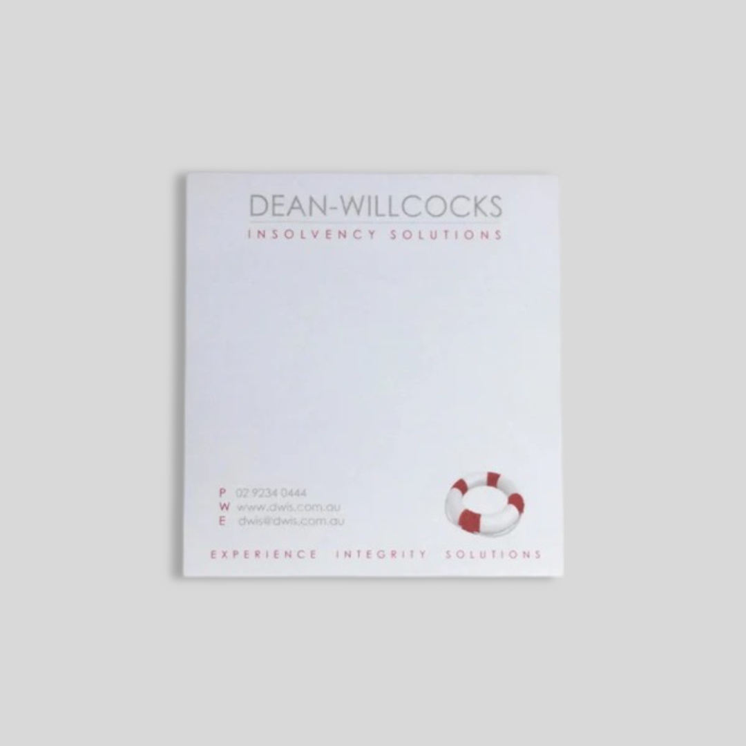 A square notepad featuring the Dean-Willcocks Insolvency Solutions branding. The design includes the company name at the top, contact details at the bottom left, and a small red and white lifebuoy graphic on the lower right. The tagline "Experience. Integrity. Solutions." is printed along the bottom, creating a professional and clean look suitable for corporate use.